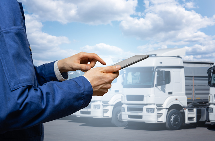 Manager with digital tablet on the background of trucks. Fleet management